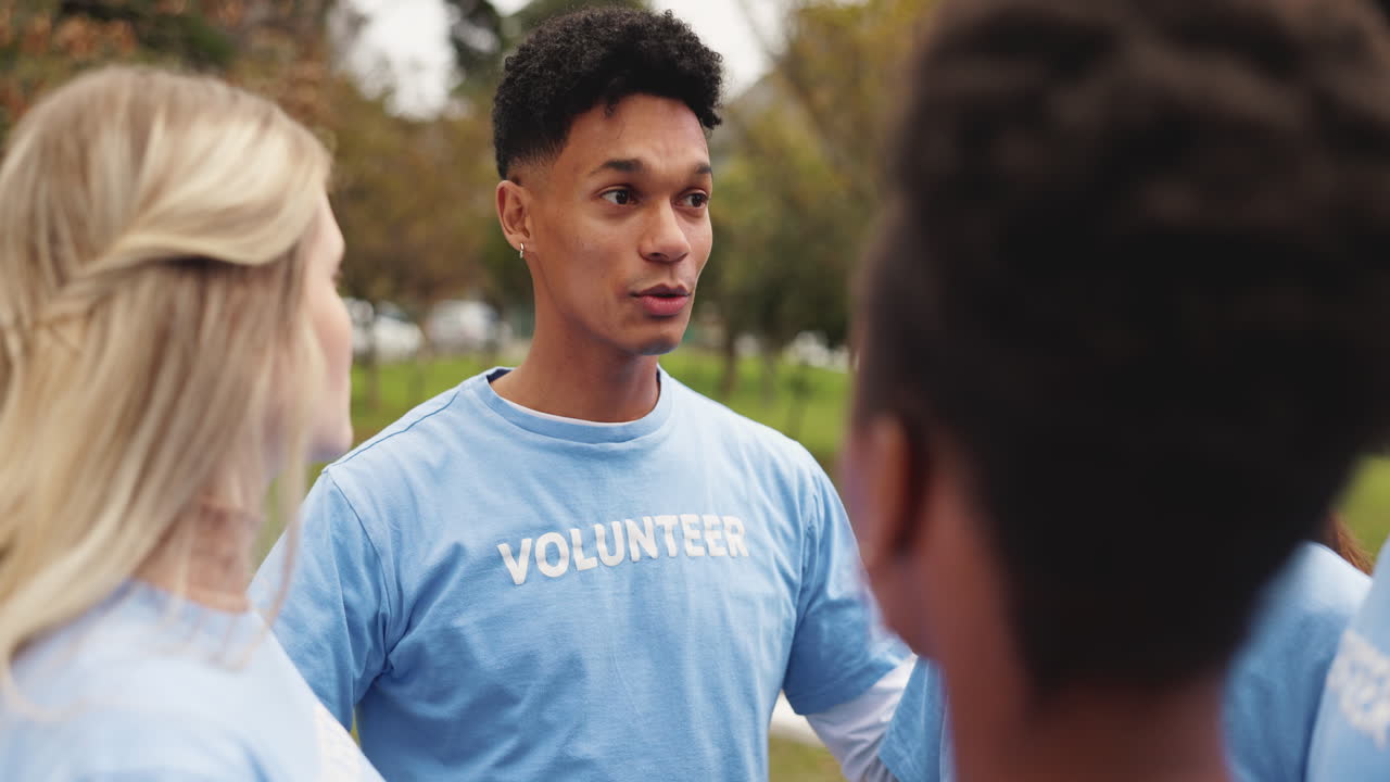grupo de voluntarios diversos sonriendo y hablando juntos en un parque