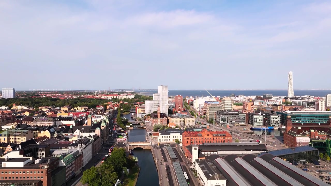 Sorvolo verso la stazione centrale di Malmö, con vista su autobus, edifici caratteristici, canale e città