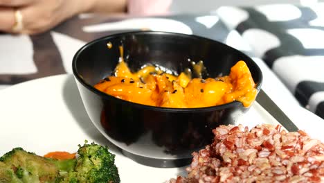 cooked red rice , vegetable salad and fish curry in a bowl on table ,