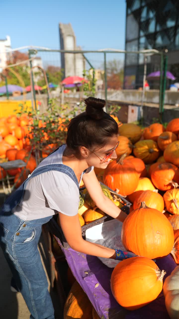 가을 시장 에서 호박 을 수확 하는 여자