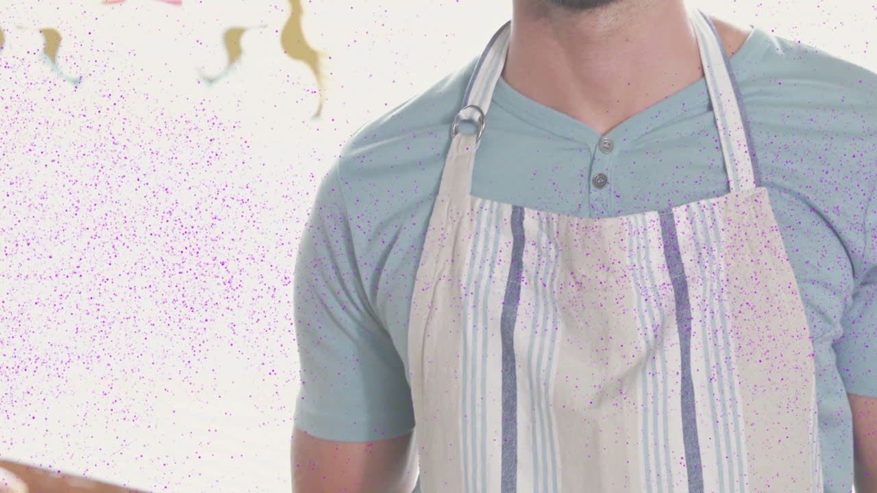 Wearing apron, man surrounded by colorful animation particles in bright setting