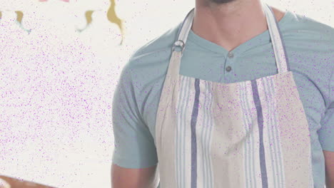 wearing apron, man surrounded by colorful animation particles in bright setting