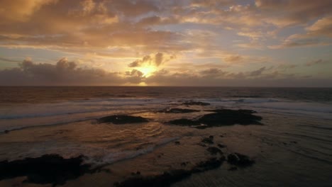 Aerial-view-of-ocean-in-golden-light-of-sunset