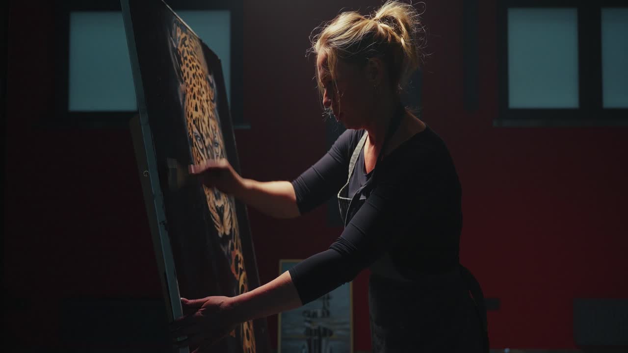 Woman Painting a Leopard on Canvas in a Studio