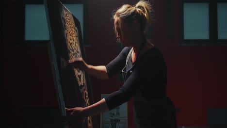 woman painting a leopard on canvas in a studio