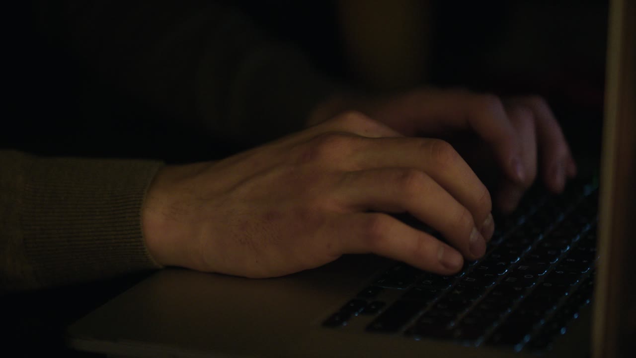 persona escribiendo en la computadora portátil por la noche
