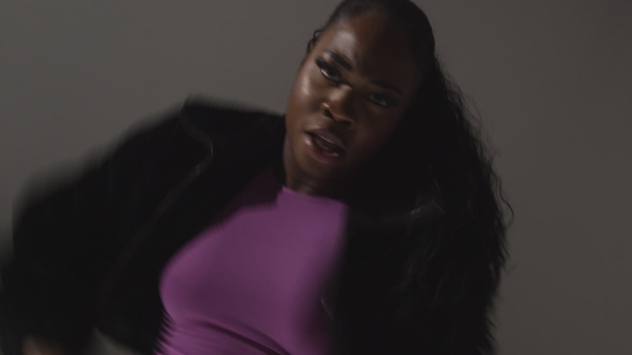 студийный портрет молодой женщины, танцующей при низком освещении на сером фоне 11