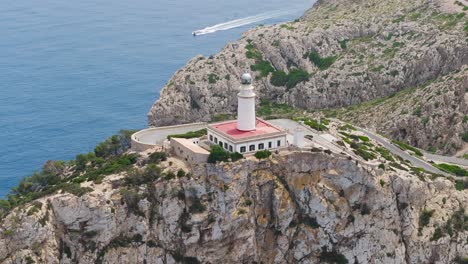 Aerial-view-of-Formentor-Lighthouse-near-rugged-limestone-cliff-edge,-Spain