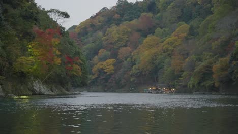 arashiyama river in autumn colors, calm peaceful scene shot