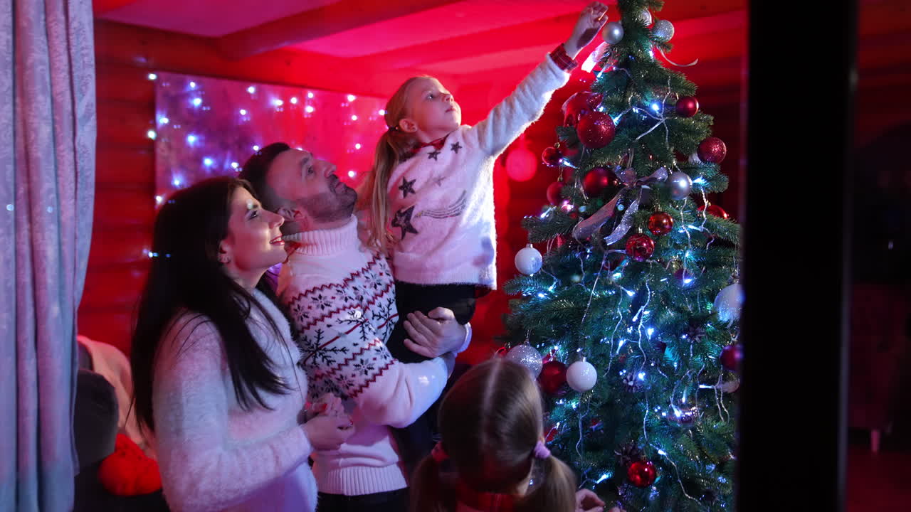 Waiting for the magic. Happy family of four decorating their fir tree and waiting for the Santa at their cozy apartments. Happy new year concept