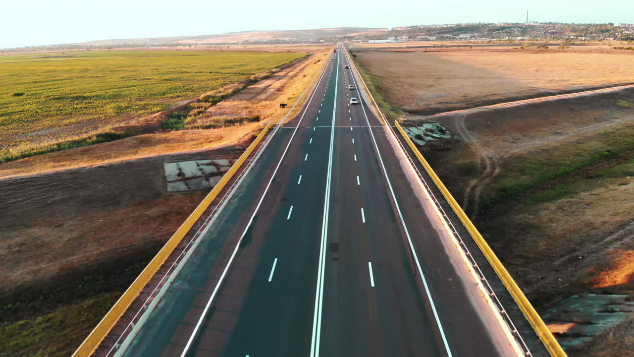 Aerial drone view of a road with moving car in highland. Green fields and hills from north part of Moldova