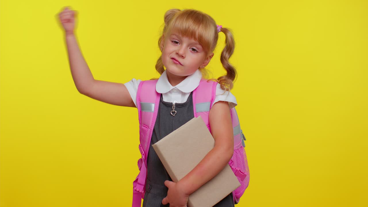 Mädchen in Schuluniform zeigt ihren Bizeps und blickt selbstbewusst, fühlt sich stark für das Lernen.