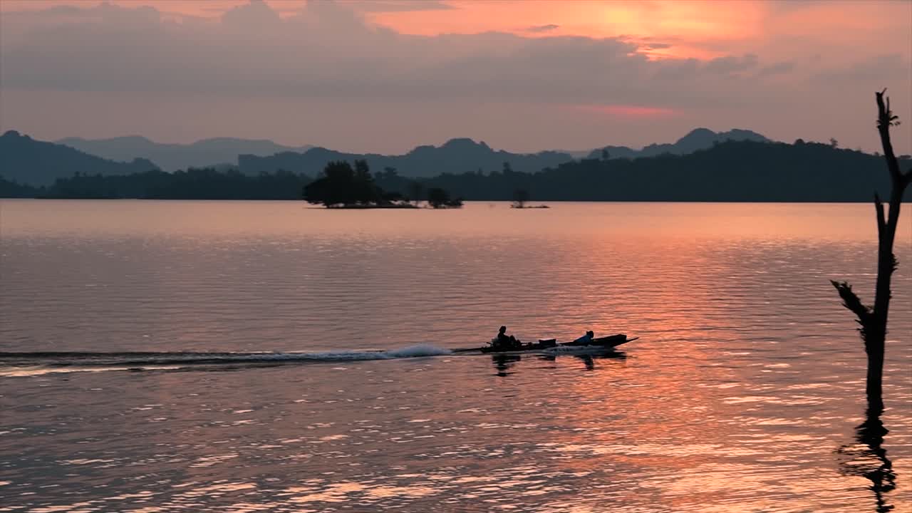 un enorme lago en el parque nacional de khao laem donde la puesta de sol es increíble, ya que los colores cálidos y brillantes se muestran cuando el sol se está poniendo