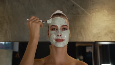 caucasian woman putting on face mask in hotel