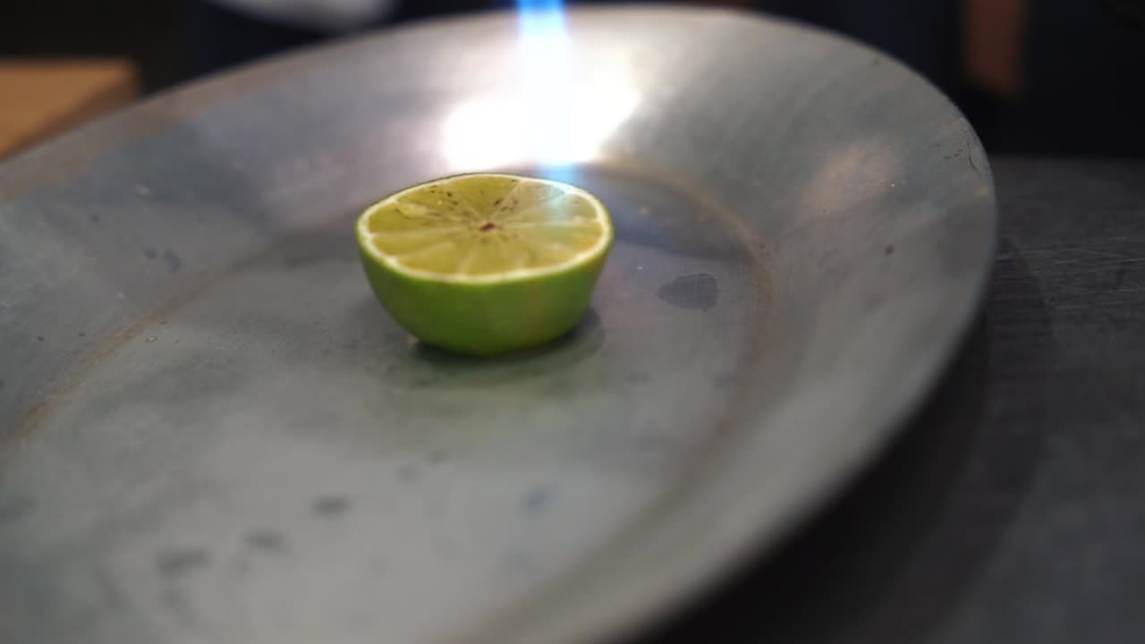 gas burner hand held used to torch a cut lime on a metal dish