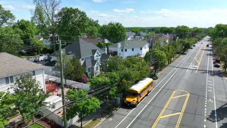 aerial view of luxury american neighborhood with villas and parking yellow school bus on road during summer day