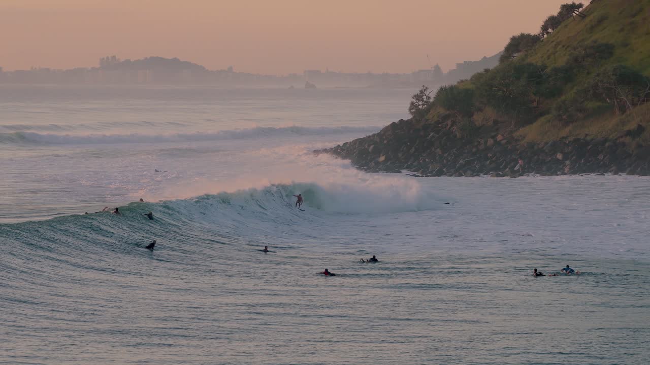 Surfare rider vågor vid soluppgången i Burleigh Heads, Gold Coast, Queensland, Australien - Drönarbild.