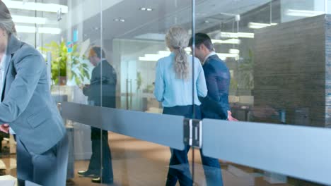 business people walking and talking in the hallway, top manager and businesswoman have conversation in the office, use desktop computer. corporate office with many busy workers.