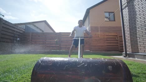 gardener laying lawn in private yard with wooden fence