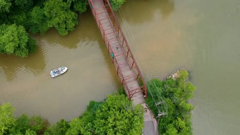 volando sobre un bote que viaja hacia un puente río abajo