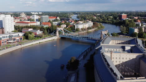 aerial shot of the river oder in wroclaw, poland, flying towards the grunwald bridge