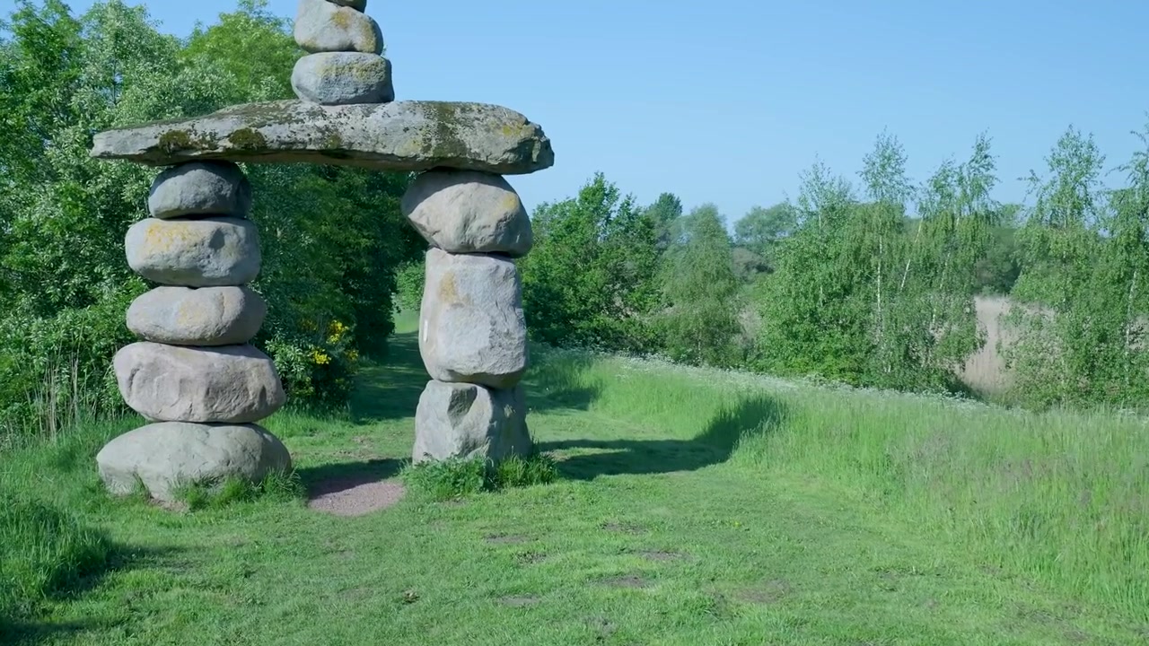 Steinhvelvskulptur på en frodig grønn eng