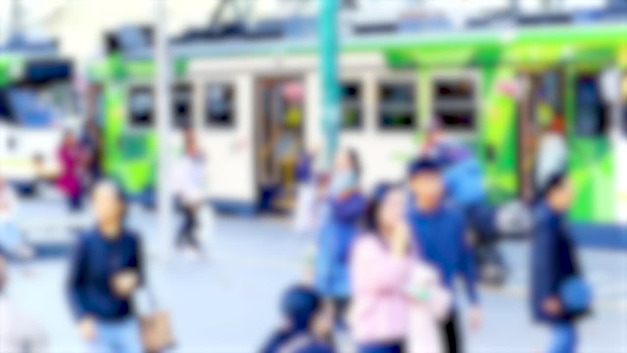 Blurred pedestrians and a tram in a bustling Melbourne street, capturing urban movement and vibrant city life