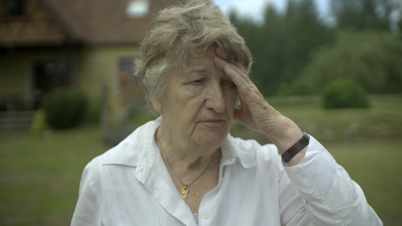 mujer mayor con la mano en la cara pensando, preocupada y triste