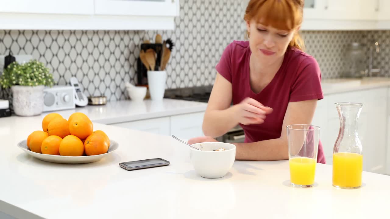 hermosa mujer usando teléfono móvil mientras desayuna 4k