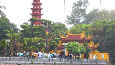 people with umbrellas at tran quoc pagoda