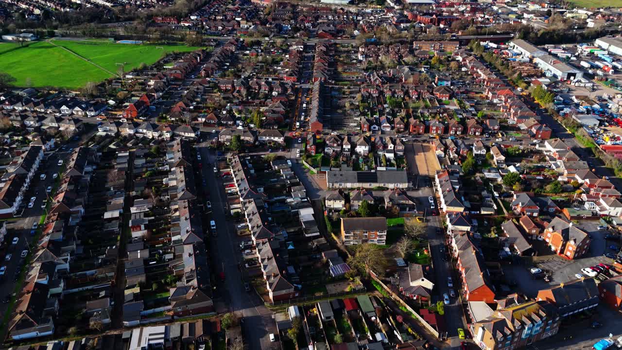 Ripresa aerea panoramica sul sobborgo di Totton a ovest del fiume a Southampton, Inghilterra, con auto che percorrono le strade trafficate e la luce del sole che si riflette sull'acqua blu del fiume con barche, in inverno