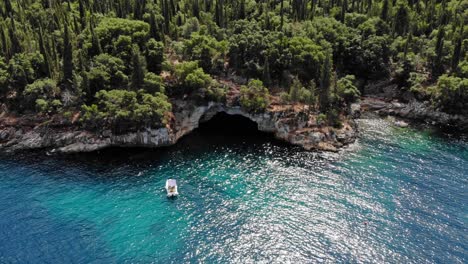 small boat docked near the forest-covered seashore in foki beach in kefalonia, greece