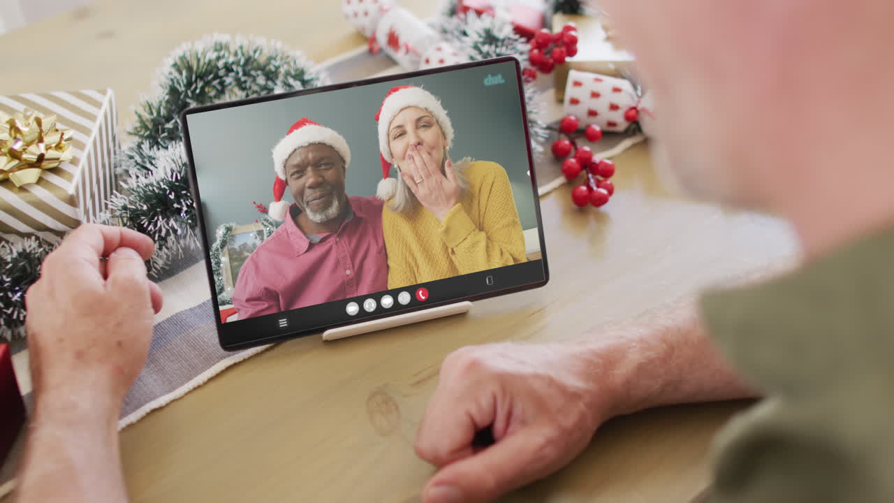 animación de un hombre caucásico mayor en una llamada de video de tableta con amigos en navidad