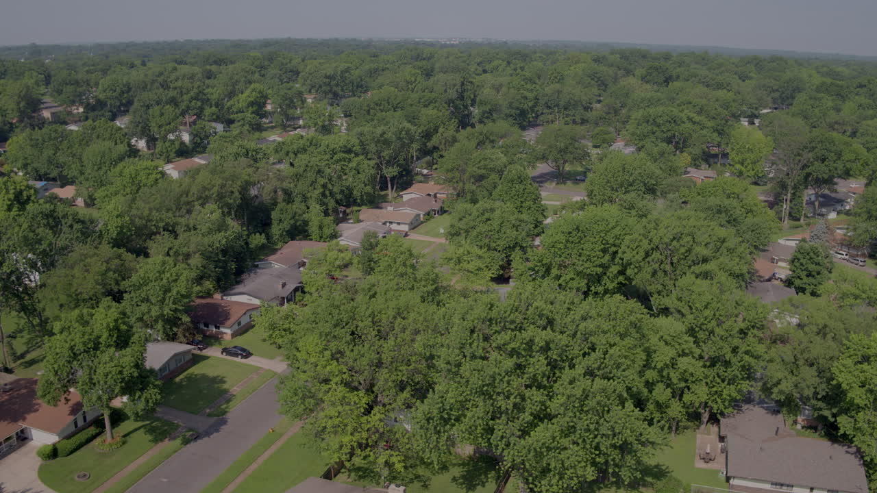 aerial flyover suburban landscape with houses trees and streets