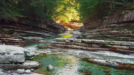 calming cinemagraph of the mountain river canyon taugl in tyrol, austria, close to  mozart birthplace salzburg on a sunny autumn day as seamless video loop. the water is rushing along naturally formed rocks and vibrant colorful autumn trees