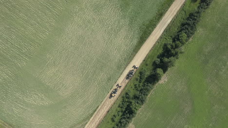 Road-graders-flattening-dirt-trail-in-countryside-of-Canada,-aerial,-top-down
