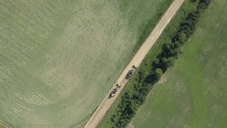 road graders flattening dirt trail in countryside of canada, aerial, top down