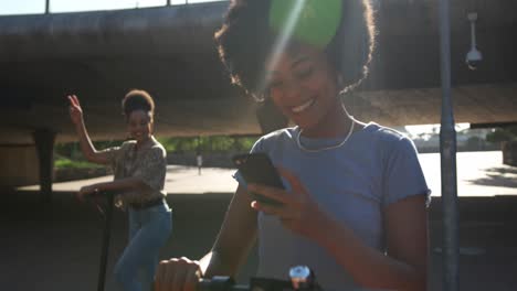 two mixed race women taking picture in park