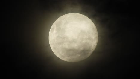 Haunted-creepy-near-full-moon-with-eerie-dark-clouds-moving-past-in-the-foreground,-perfect-for-Halloween,-scary-dark-themed,-celestial-footage