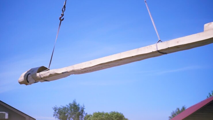 Large Wooden Beam Being Lifted by Crane