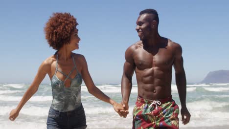 pareja tomados de la mano y corriendo juntos en la playa 4k