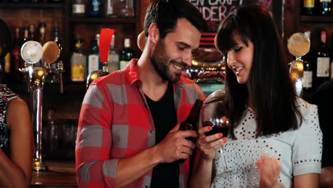 grupo de amigos sonrientes interactuando mientras beben alcohol