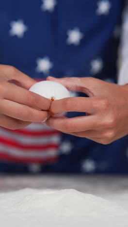 breaking eggs for baking with an american flag apron