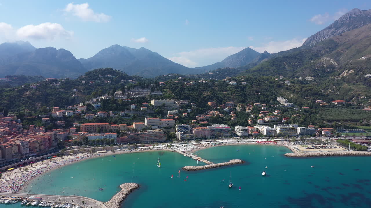 Vista aerea della costa di Mentone con i porti e le Alpi sullo sfondo, giornata di sole