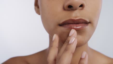 de cerca hermosa mujer afroamericana tocando la cara con las manos acariciando piel suave y saludable disfrutando de un tratamiento natural de cuidado de la piel sobre un fondo blanco concepto de belleza