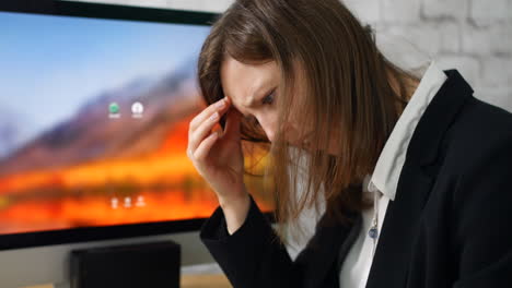 Close-up-of-woman-in-office-stressed-and-overworked-with-paperwork-and-bills