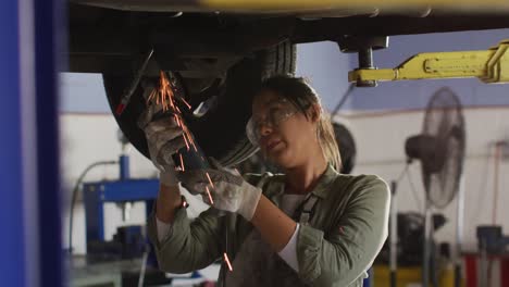 Video-Einer-Gemischtrassigen-Kfz-Mechanikerin,-Die-Eine-Schleifmaschine-Verwendet