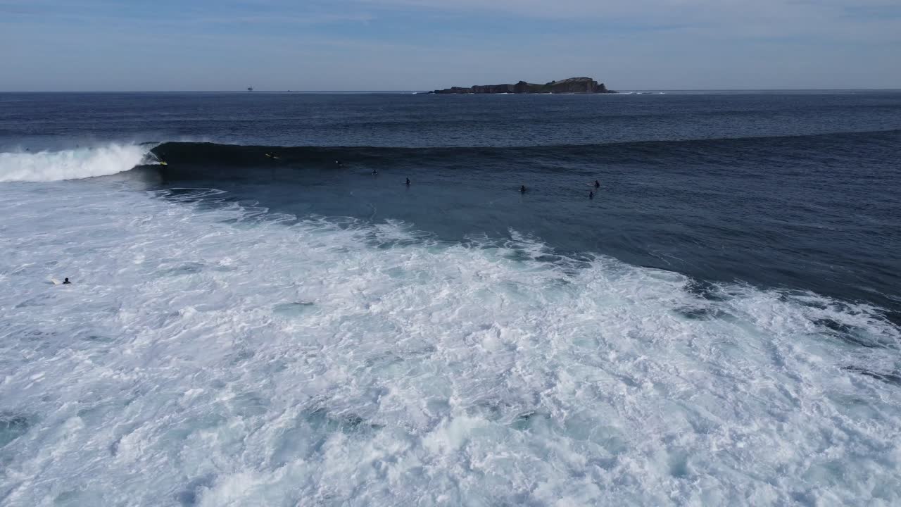 스페인 북부 바스크 지방의 문다카의 유명한 큰 파도에서 라인업에 있는 많은 서퍼들, 드론