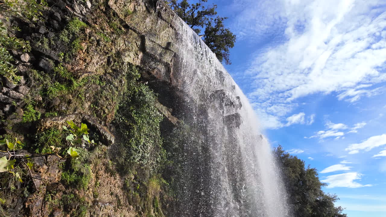 View of the waterfall at Castle Hill in Nice, France with clear water cascading down the rocks