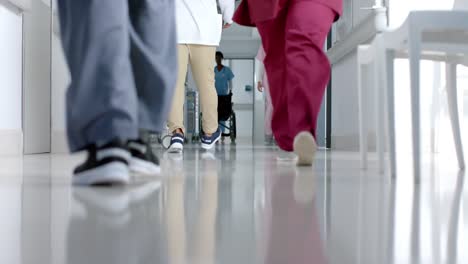 Low-section-of-diverse-doctors-walking-in-corridor-at-hospital,-slow-motion